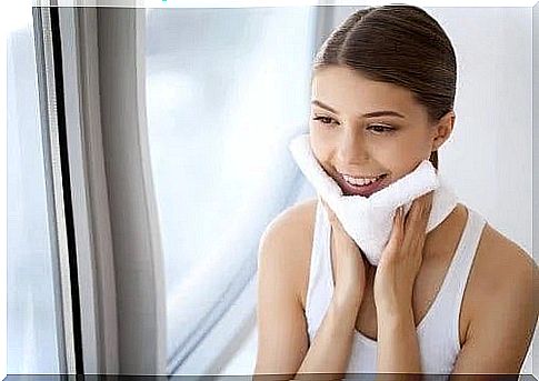 Woman wiping her face with a towel