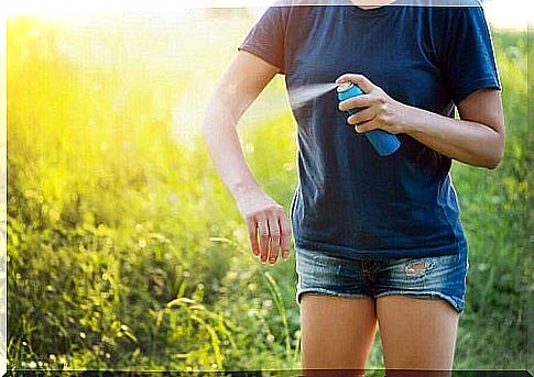 Woman applying an insecticide spray outdoors