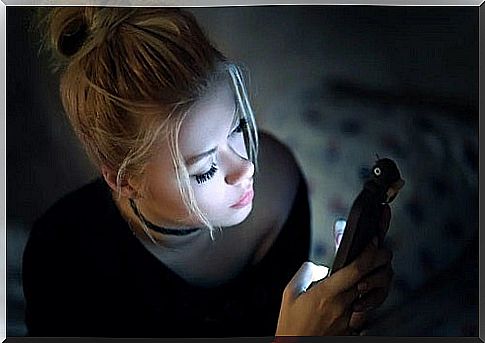 Young woman buttoning the phone at night